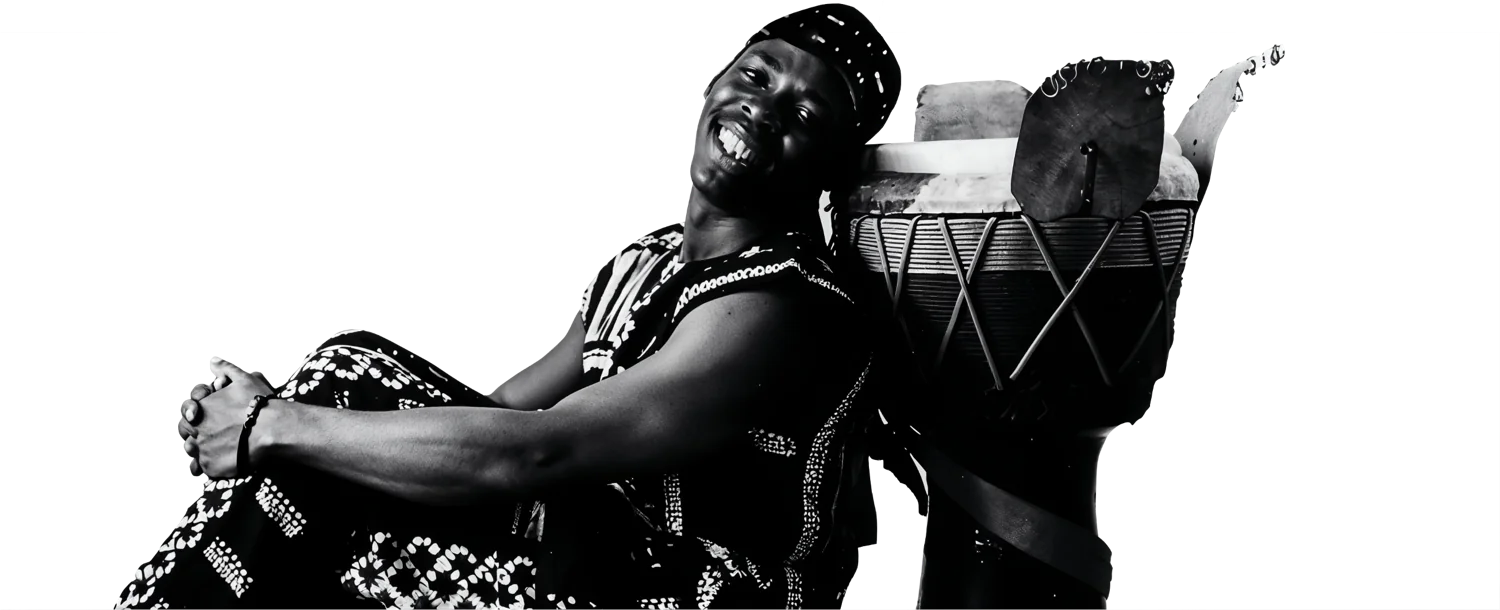 Percussionniste souriant adossé à son djembé, photographie en noir et blanc