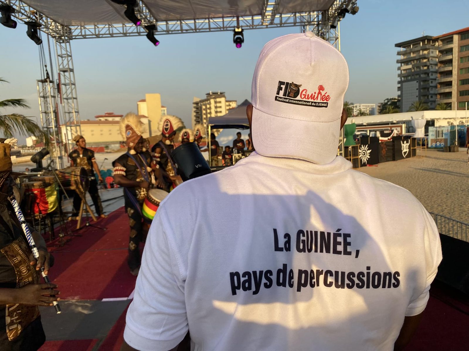 Devant la scène de la plage de Camayenne : casquette et t-shirt du festival, danseurs traditionnels, édition 2024
